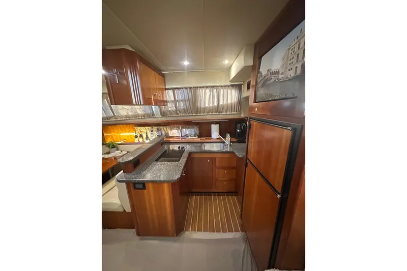 Slide: The Image of 2008 Cruisers Yachts 415 Express Motoryacht kitchen with wood cabinetry and modern appliances. - 8