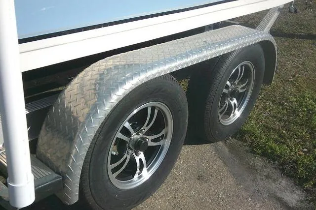 Slide: The Image of Trailer wheels of a 2022 Carolina Skiff 21 Ultra Elite boat on pavement. - 17