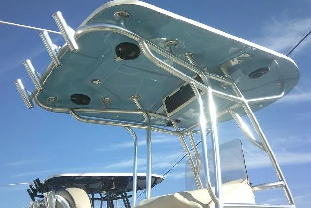 Slide: The Image of 2022 Carolina Skiff 21 Ultra Elite T-top with rod holders against blue sky. - 19