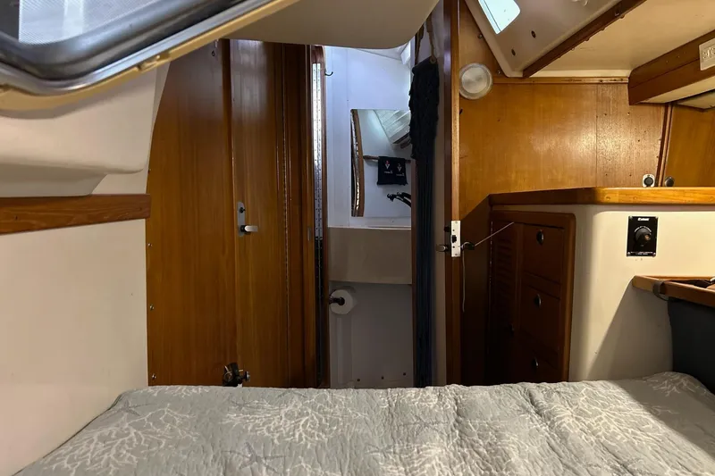Slide: The Image of Interior of a 1999 Catalina 42 MkII sailboat, featuring wood paneling and a cozy cabin. - 13