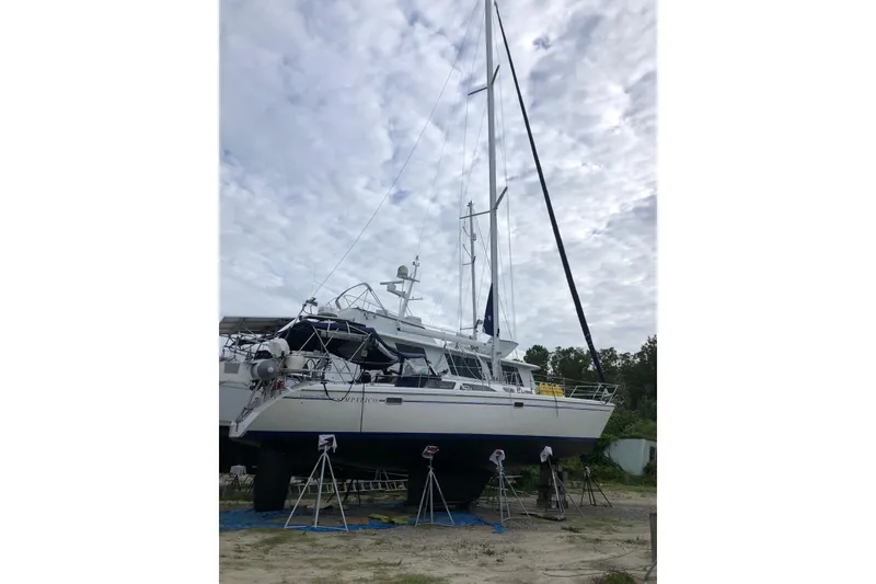 Slide: The Image of 1999 Catalina 42 MkII sailboat on land, cloudy sky background. - 2