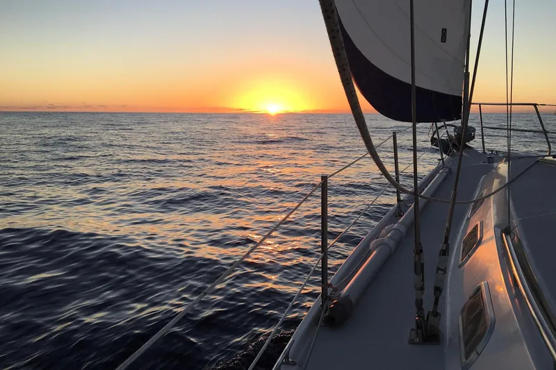 Slide: The Image of Sailing on a 1999 Catalina 42 MkII at sunset over calm ocean waters. - 36