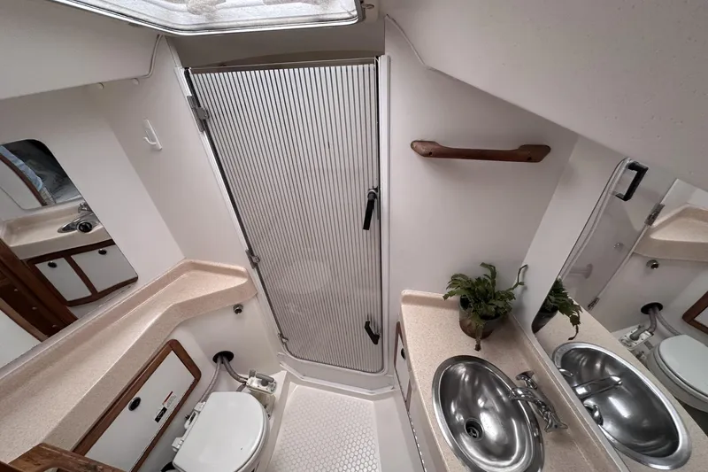 Slide: The Image of Bathroom interior of a 1999 Catalina 42 MkII yacht, featuring sink, toilet, and shower. - 39