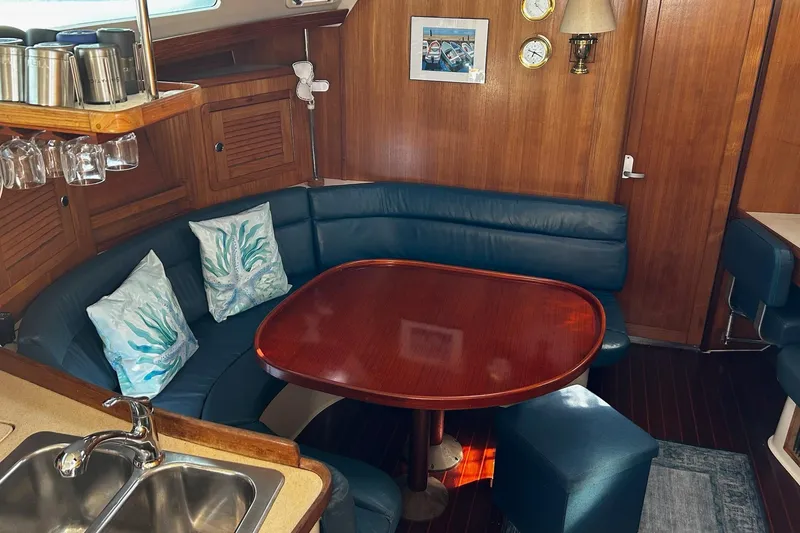 Slide: The Image of Cozy interior of 1999 Catalina 42 MkII sailboat with wooden table and blue seating. - 4