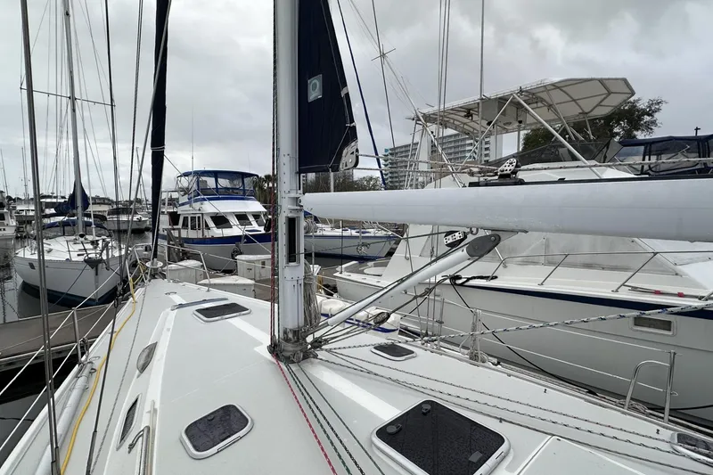 Slide: The Image of Sailboats docked at marina, featuring a 1999 Catalina 42 MkII under cloudy skies. - 49