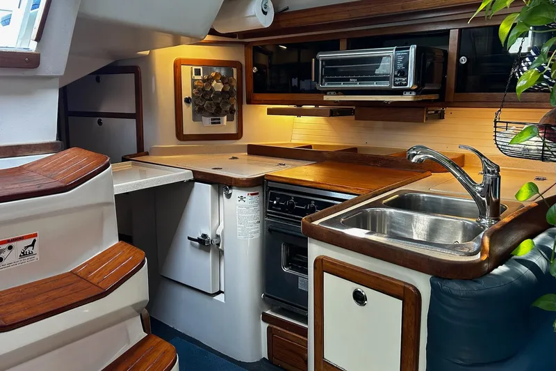 Slide: The Image of Interior of a 1999 Catalina 42 MkII yacht kitchen with wooden cabinetry and modern appliances. - 7