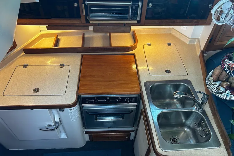 Slide: The Image of 1999 Catalina 42 MkII yacht kitchen with stove, dual sink, and ample counter space. - 8