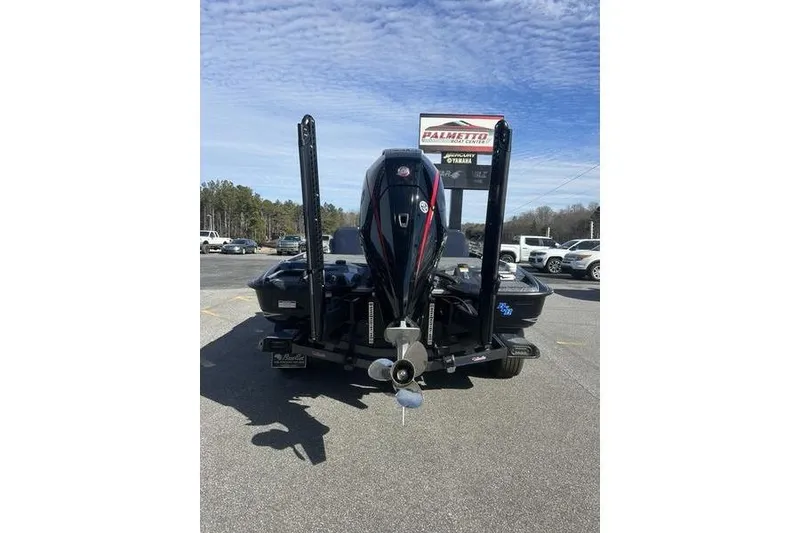 Slide: The Image of 2026 Bass Cat Lynx STS boat with powerful outboard motor in a parking lot. - 4