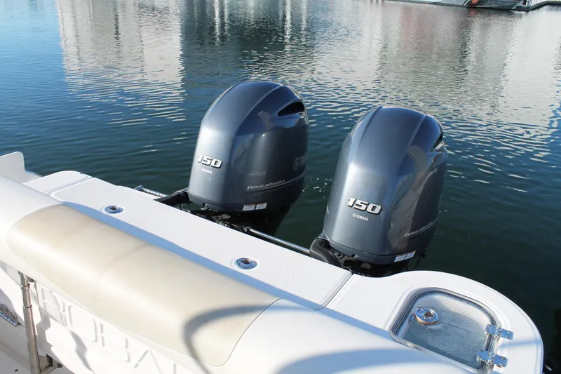 Slide: The Image of 2016 Robalo R247 Dual Console with twin Yamaha 150 engines on calm water. - 11