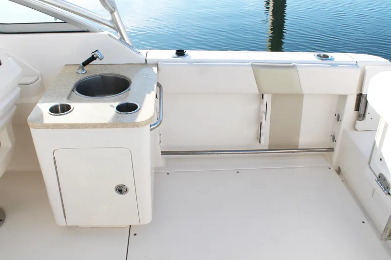 Slide: The Image of 2016 Robalo R247 Dual Console boat interior with sink and storage. - 17