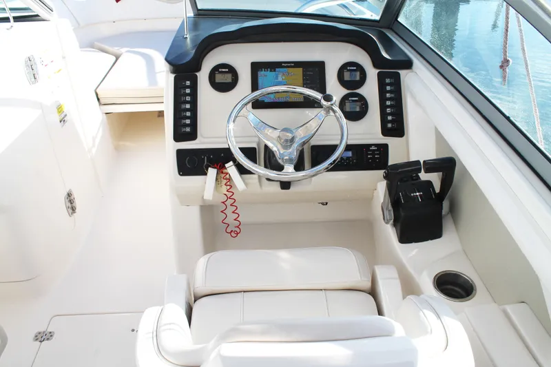 Slide: The Image of 2016 Robalo R247 Dual Console boat cockpit with steering wheel and control panel. - 21