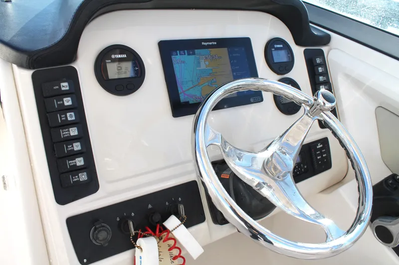 Slide: The Image of 2016 Robalo R247 Dual Console dashboard with steering wheel and navigation controls. - 23