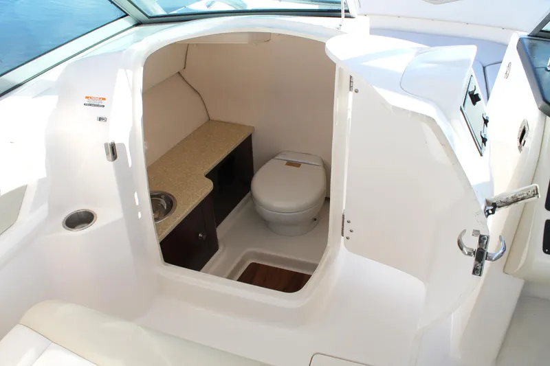 Slide: The Image of 2016 Robalo R247 Dual Console boat interior with compact bathroom amenities. - 25