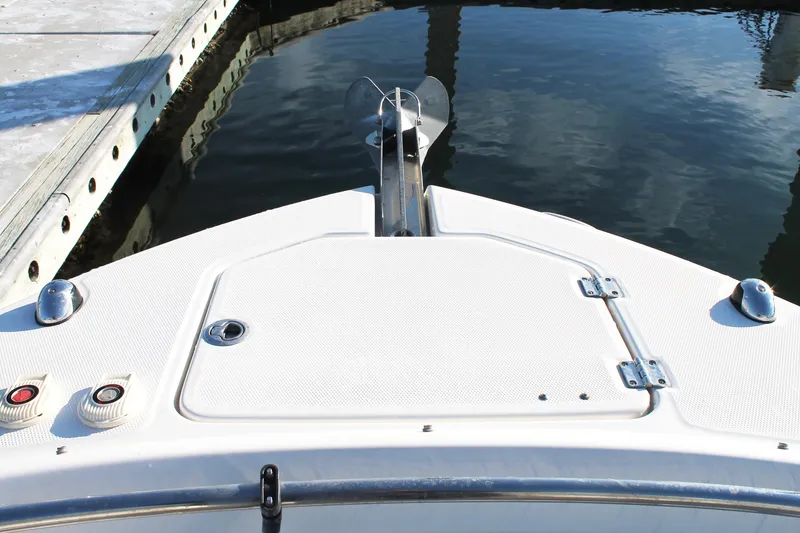 Slide: The Image of 2016 Robalo R247 Dual Console boat bow with anchor, docked on calm water. - 32
