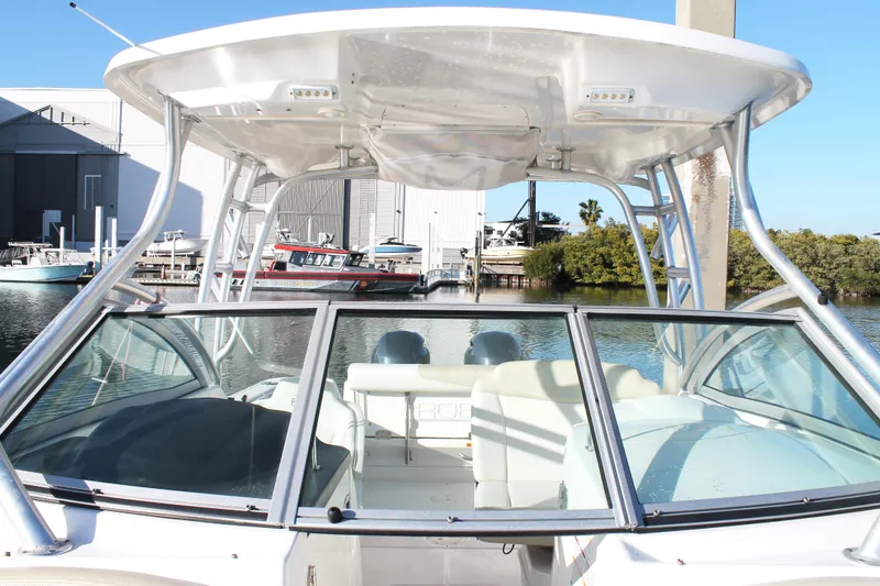 Slide: The Image of 2016 Robalo R247 Dual Console boat docked, featuring spacious seating and sleek design. - 33