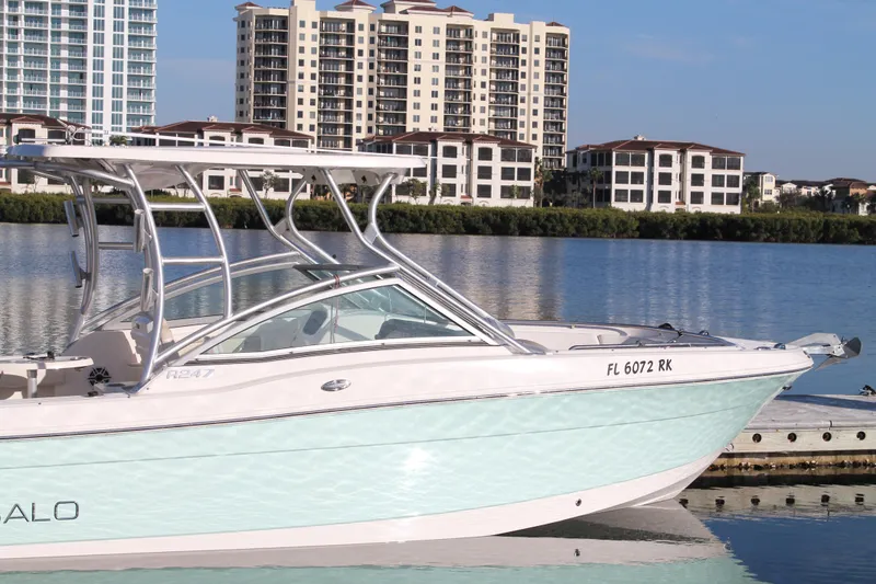 Slide: The Image of 2016 Robalo R247 Dual Console boat docked by waterfront buildings. - 4