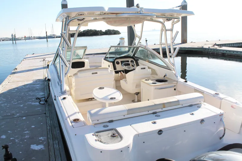 Slide: The Image of 2016 Robalo R247 Dual Console boat docked, showcasing spacious seating and helm area. - 8