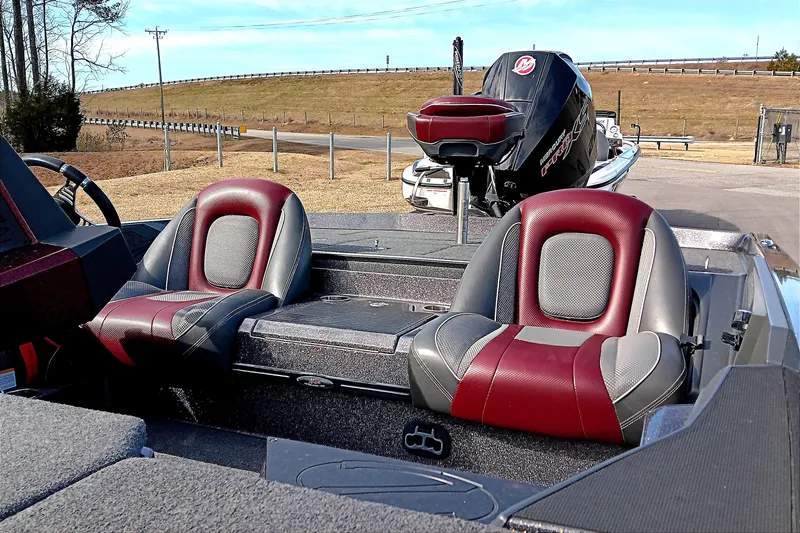 Slide: The Image of 2020 Ranger Z519 boat interior with red and gray seats, parked outdoors. - 15