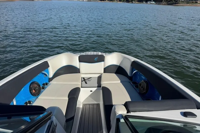 Slide: The Image of 2018 MasterCraft X26 boat interior with spacious seating on a calm lake. - 1