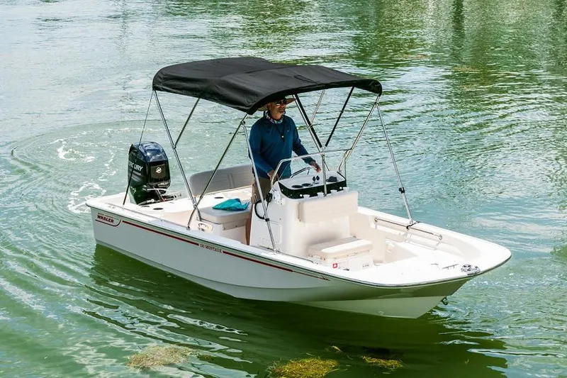Slide: The Image of Manufacturer Provided Image: 2020 Boston Whaler 150 Montauk boat cruising on water with canopy. - 15