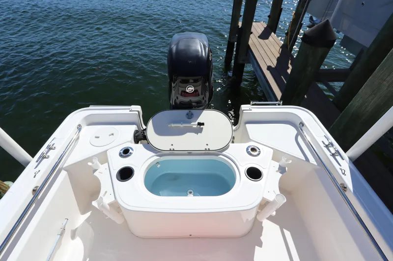 Slide: The Image of 2020 Boston Whaler 150 Montauk boat with open livewell and outboard motor. - 4