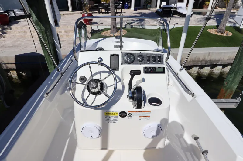 Slide: The Image of 2020 Boston Whaler 150 Montauk boat console with steering wheel and controls. - 8