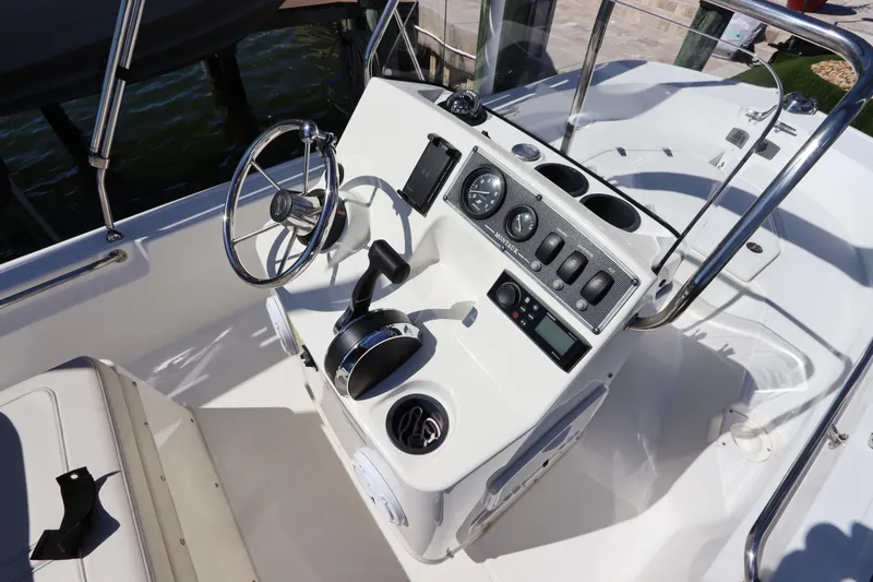 Slide: The Image of 2020 Boston Whaler 150 Montauk boat console with steering wheel and controls. - 9