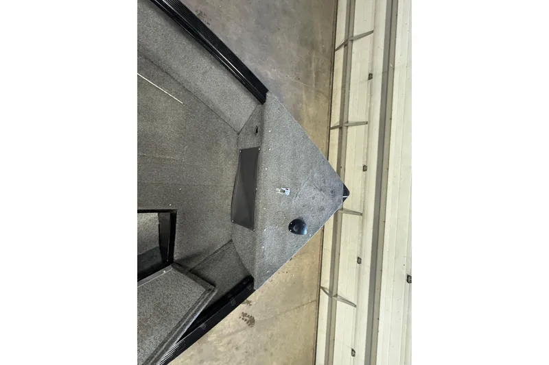 Slide: The Image of 2017 Lund 1750 Rebel XS Sport boat interior with gray carpet and storage compartments. - 15