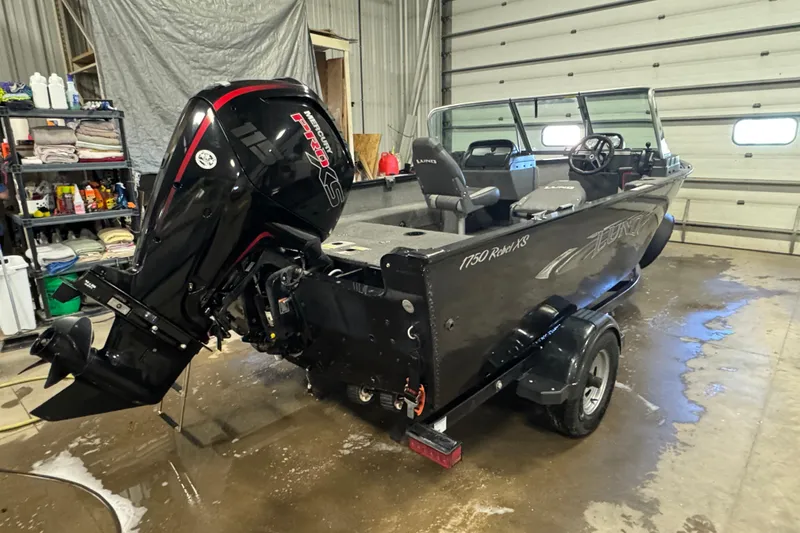 Slide: The Image of 2017 Lund 1750 Rebel XS Sport boat in garage, featuring powerful outboard motor. - 3