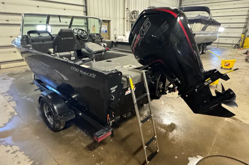 Slide: The Image of 2017 Lund 1750 Rebel XS Sport boat in garage with outboard motor and trailer. - 4
