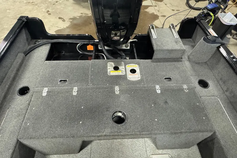 Slide: The Image of 2017 Lund 1750 Rebel XS Sport boat interior with storage compartments and motor. - 5