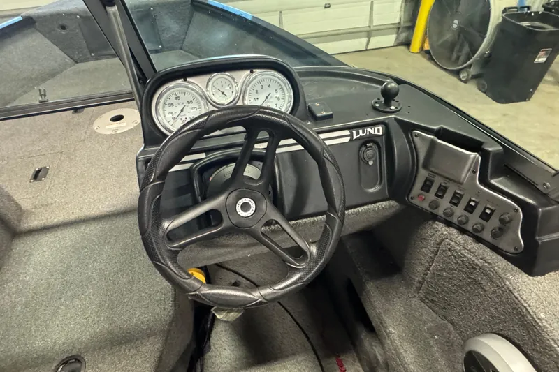 Slide: The Image of 2017 Lund 1750 Rebel XS Sport boat dashboard with steering wheel and control panel. - 8