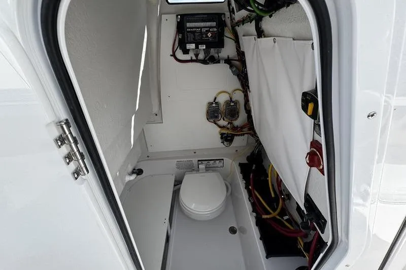 Slide: The Image of 2026 Sportsman Open 232 Center Console interior with marine toilet and wiring. - 8