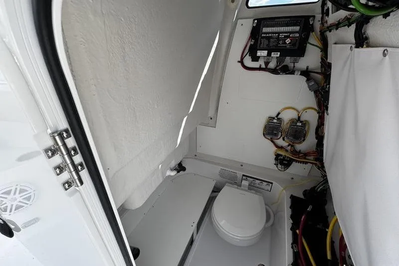 Slide: The Image of Interior of 2026 Sportsman Open 232 Center Console boat with toilet and wiring. - 9