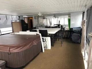 Slide: The Image of 2008 Destination Yachts houseboat interior with hot tub and dining area. - 36