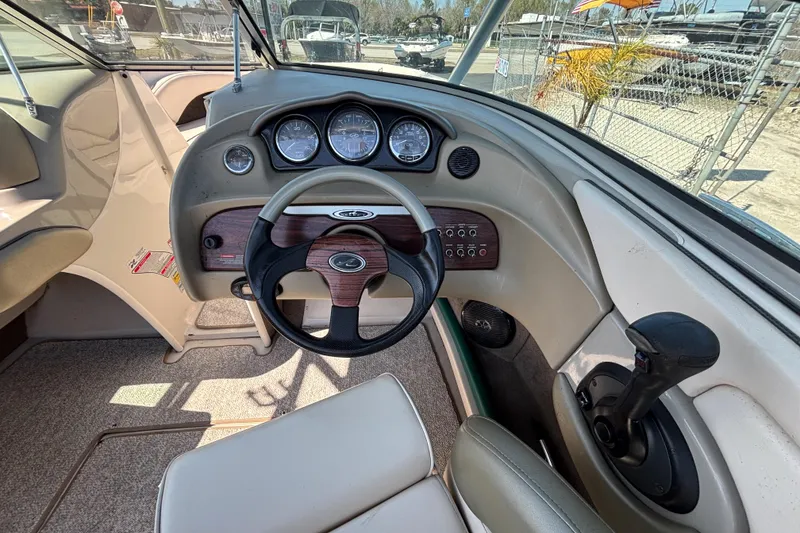 Slide: The Image of 2005 Sea Ray 220 Select boat dashboard with steering wheel and control panel. - 14
