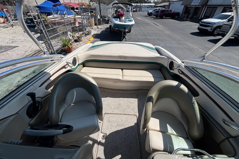 Slide: The Image of 2005 Sea Ray 220 Select boat interior with seating and steering wheel, parked outdoors. - 16