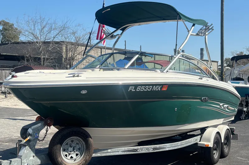 Slide: The Image of 2005 Sea Ray 220 Select boat on trailer, green hull, parked outdoors. - 3