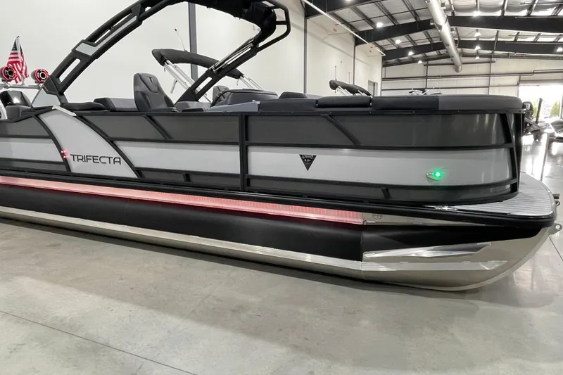 Slide: The Image of 2025 Trifecta 23RFSS pontoon boat in showroom, sleek design with modern features. - 2