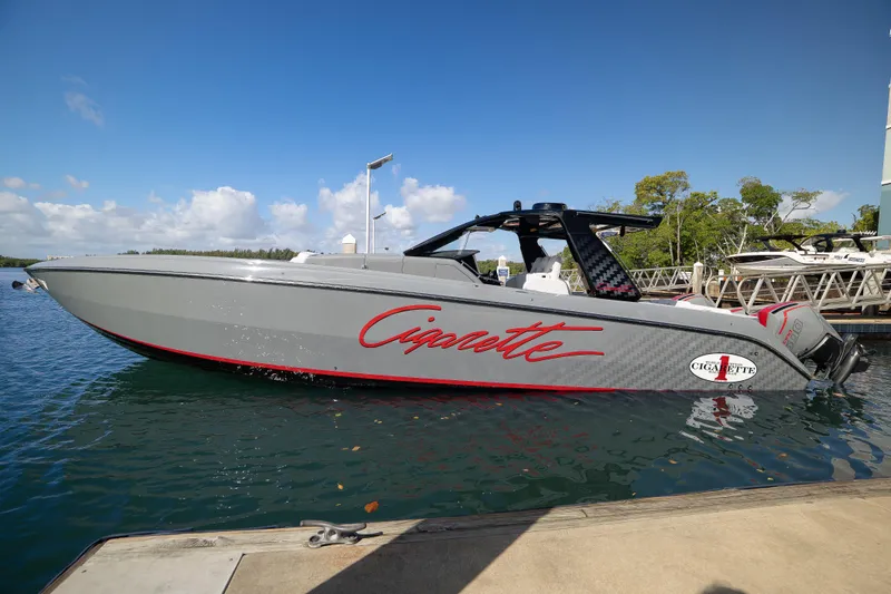 Slide: The Image of 2026 Cigarette 42' Auroris boat docked on a sunny day, featuring sleek design and modern aesthetics. - 1