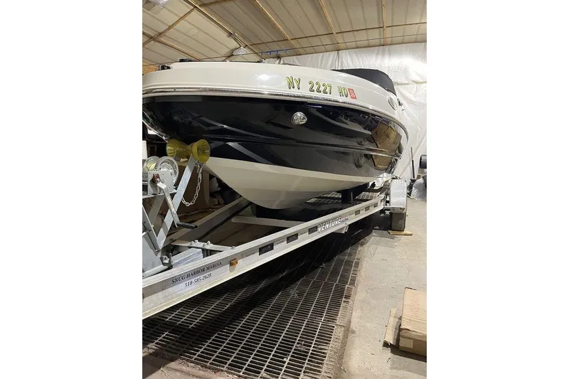 The Image of 2020 Stingray 208 CR boat on trailer in indoor storage facility. - 1