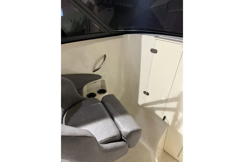 Slide: The Image of 2020 Stingray 208 CR boat interior with gray seating and storage compartment. - 11
