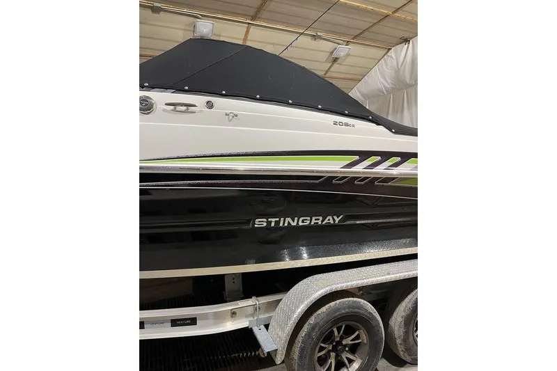 Slide: The Image of 2020 Stingray 208 CR boat on trailer in indoor storage. - 2