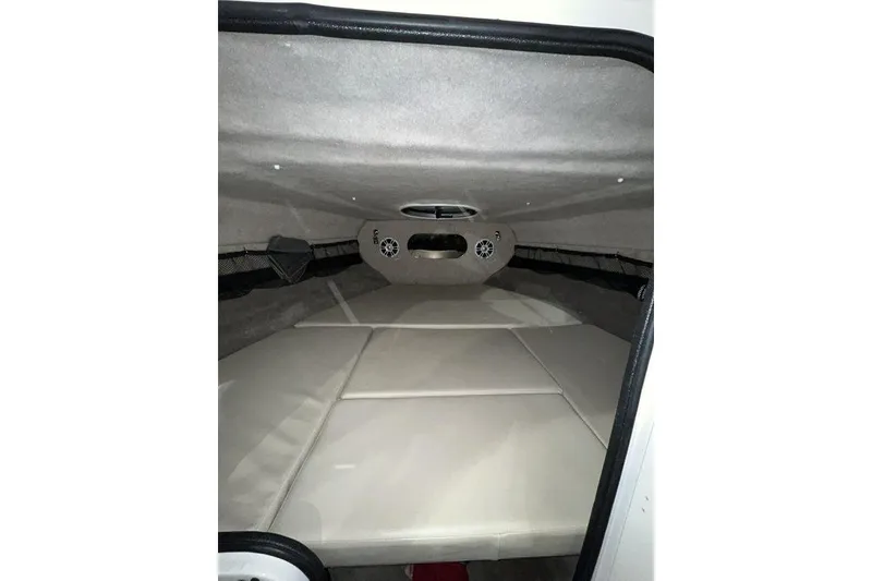 Slide: The Image of 2020 Stingray 208 CR boat cabin interior with cushioned seating and speakers. - 24