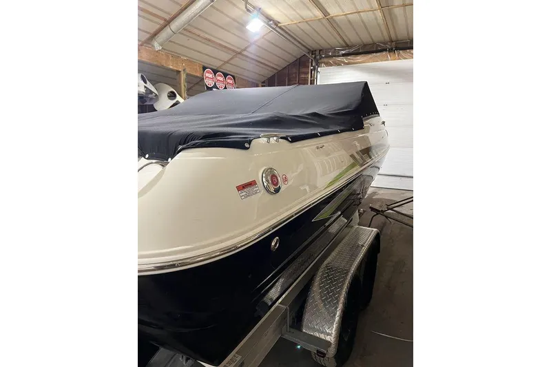 Slide: The Image of 2020 Stingray 208 CR boat with cover on trailer in garage. - 3