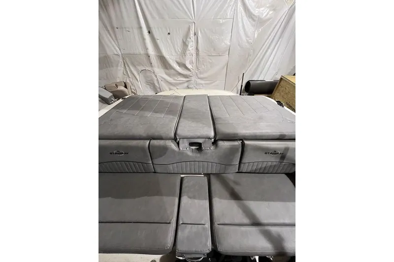 Slide: The Image of 2020 Stingray 208 CR boat interior with gray cushioned seating in a storage area. - 4