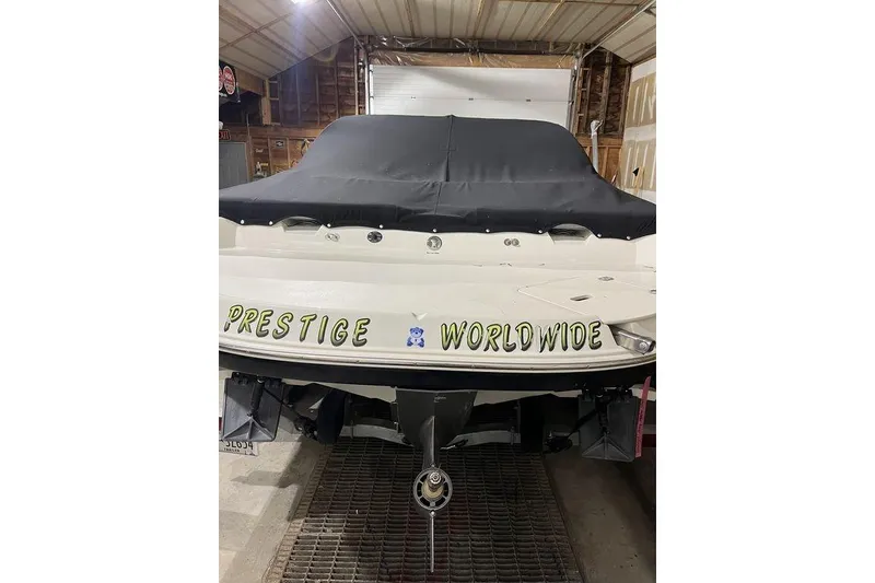 Slide: The Image of 2020 Stingray 208 CR boat in garage, covered, with "Prestige Worldwide" text. - 5