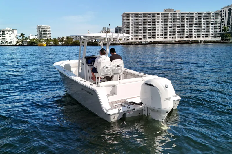 The Image of 2018 Sportsman Heritage 241 Center Console boat on water near urban buildings. - 0