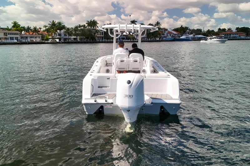 Slide: The Image of 2018 Sportsman Heritage 241 Center Console boat on calm water, with scenic waterfront homes. - 13