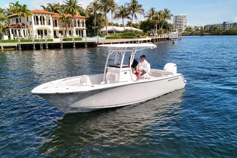 Slide: The Image of 2018 Sportsman Heritage 241 Center Console boat cruising near waterfront homes. - 14